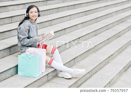 Teenage girl sitting on steps 70357937