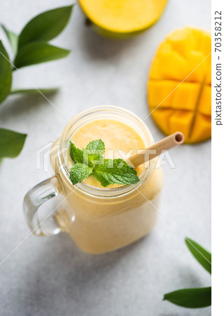 Mango smoothie, mango lassi or cocktail with bamboo drinking straw Mango smoothie, mango lassi or cocktail with bamboo drinking straw 70358212