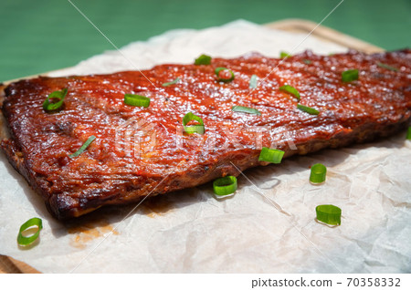 Close up board with pork ribs grilled with BBQ sauce, peanuts and jalapeno Close up board with pork ribs grilled with BBQ sauce, peanuts and jalapeno 70358332