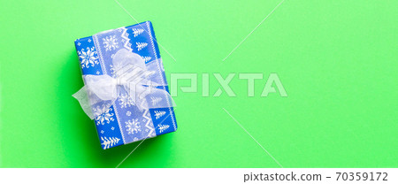 wrapped Christmas or other holiday handmade present in paper with white ribbon on green background. Present box, decoration of gift on colored table, top view with copy space wrapped Christmas or other holiday handmade present in paper with white ribbon on green background. Present box, decoration of gift on colored table, top view with copy space 70359172