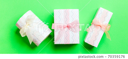 Top view Christmas present box with Colored bow on green background Top view Christmas present box with Colored bow on green background 70359176