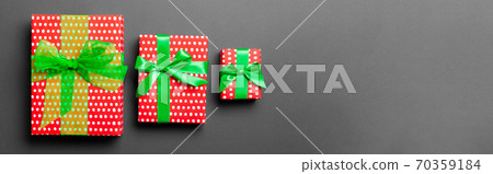 Top view Christmas present box with green bow on black background 70359184