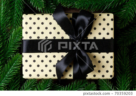 Top view of festive gift box decorated with green fir tree branches. Christmas time with copy space Top view of festive gift box decorated with green fir tree branches. Christmas time with copy space 70359203