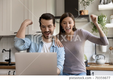 Euphoric young family couple looking at laptop screen. Euphoric young family couple looking at laptop screen. 70359877