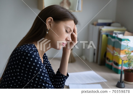Unhappy tired woman suffering from overload working day. Unhappy tired woman suffering from overload working day. 70359878