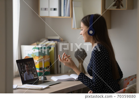Happy female student involved in interesting online discussion with teacher. Happy female student involved in interesting online discussion with teacher. 70359880