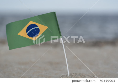 National table flag of Brazil on sea background. Flag of Brazil on sandy shore. 70359903