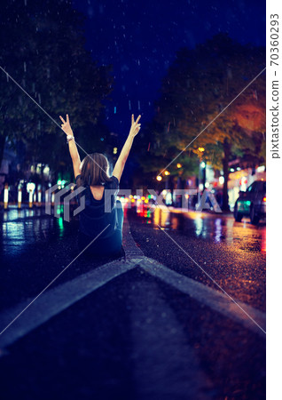 Woman sitting alone empty road during rain Woman sitting alone empty road during rain 70360293