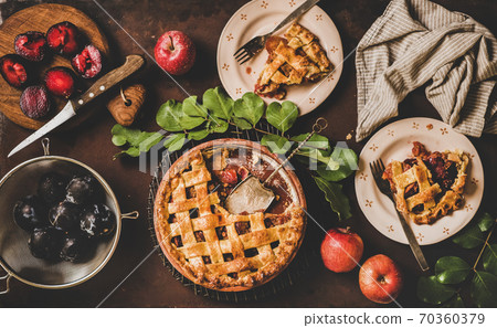 Flat-lay of apple and plum pie and tea setting 70360379
