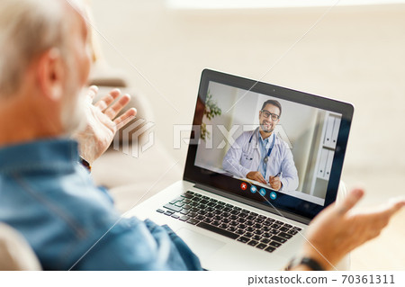 Senior man speaking with online doctor. 70361311