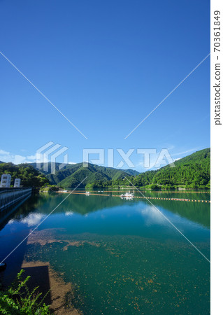 Lake Okutama in summer, Okochi dam from the north shore, lake surface and mountains on the south shore Lake Okutama in summer, Okochi dam from the north shore, lake surface and mountains on the south shore 70361849