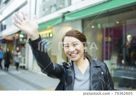 A woman waving a hand 70362605