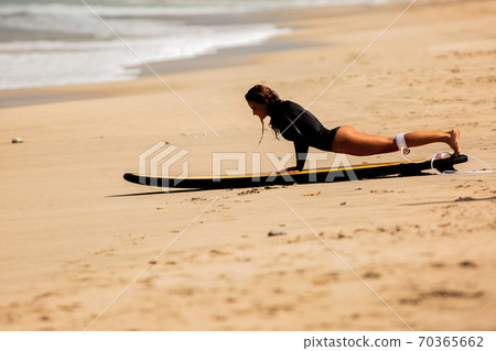 beautiful girl get up on a surfboard on the sand beautiful girl get up on a surfboard on the sand 70365662