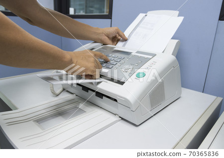 hand man are using a fax machine in the office, equipment for data transmission. 70365836