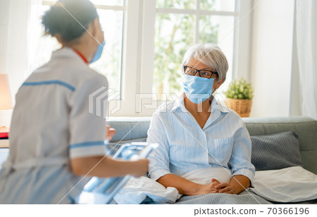 Doctor and senior woman wearing facemasks Doctor and senior woman wearing facemasks 70366196