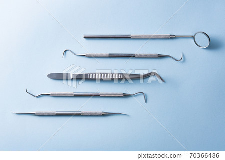 Dental instruments on a blue background 70366486