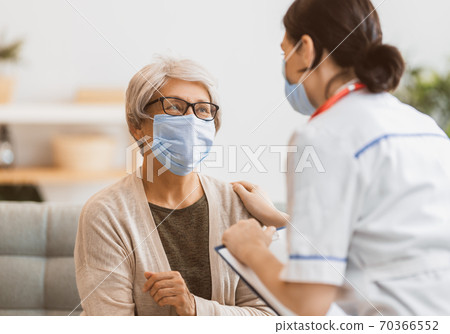 Doctor and senior woman wearing facemasks Doctor and senior woman wearing facemasks 70366552
