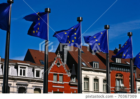 Flags in front of the Berlaymont building in Brussels and old typical houses Flags in front of the Berlaymont building in Brussels and old typical houses 70367309