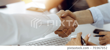 Two businessmen shaking hands in sunny office, close-up. Colleagues applauding of success meeting end 70367852