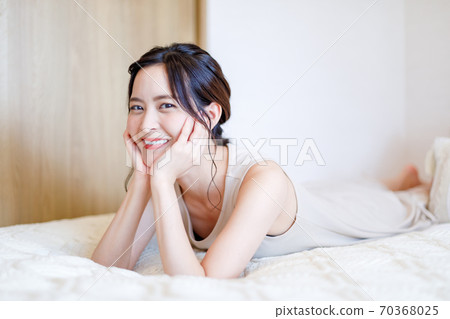 一個女人躺在她的臉頰躺在床上 一個女人躺在她的臉頰躺在床上 70368025
