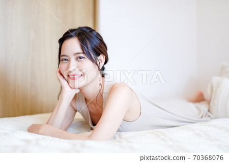 Woman lying on her bed with her cheeks Woman lying on her bed with her cheeks 70368076