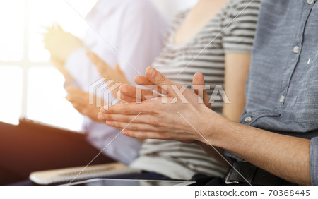 Business people clapping at meeting or conference, close-up of hands. Group of unknown businessmen and women in sunny office Business people clapping at meeting or conference, close-up of hands. Group of unknown businessmen and women in sunny office 70368445