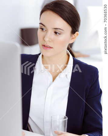 Businesswoman working with computer in office. Lawyer or accountant sitting at work, headshot. Business concept Businesswoman working with computer in office. Lawyer or accountant sitting at work, headshot. Business concept 70368530