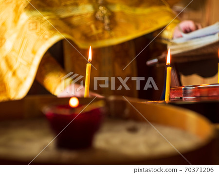 Red glowing candles in a church. Christening Orthodox ceremony background. Red glowing candles in a church. Christening Orthodox ceremony background. 70371206