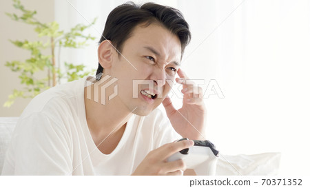 A man playing a video game in the living room A man playing a video game in the living room 70371352