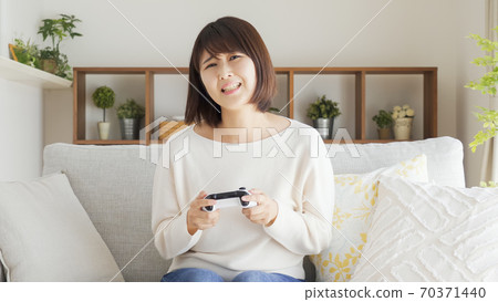 Woman playing video games in the living room 70371440