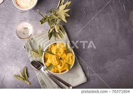 Tortellini with sage, ricotta and spinach. Italian pasta and white wine. Traditional Bologna cuisine Tortellini with sage, ricotta and spinach. Italian pasta and white wine. Traditional Bologna cuisine 70371804