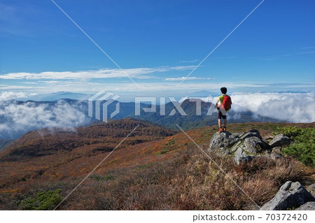 Climbers looking at the scenery from the rocky area of Mt. Funagata Climbers looking at the scenery from the rocky area of Mt. Funagata 70372420