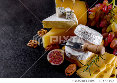 Beautiful delicious camembert cheese, parmesan, brie with grapes and figs Beautiful delicious camembert cheese, parmesan, brie with grapes and figs 70372492