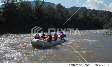 The inflatable boat on a fast stream of water. The inflatable boat on a fast stream of water. 70372883