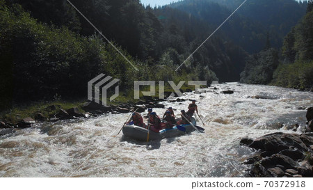 People in helmets are having fun on the river. People in helmets are having fun on the river. 70372918