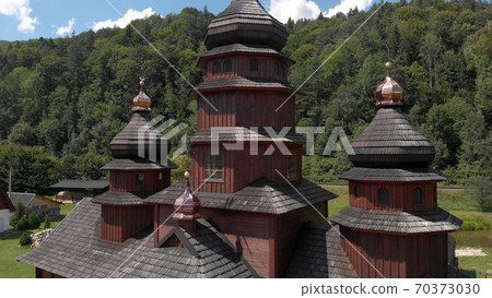Wooden church with shiny domes. 70373030