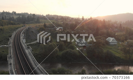 The sun goes down over the railroad. 70373166