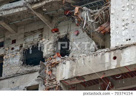 Demolition work on reinforced concrete structure - wall with holes 70374154