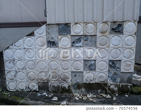 Exterior walls that are broken and need repair or painting 70374556