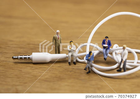 Businessmen discussing mini plugs and tangled cables 70374927