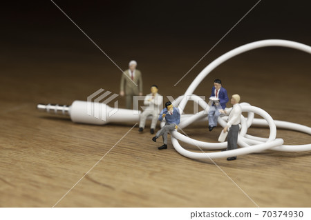 Businessmen discussing mini plugs and tangled cables 70374930
