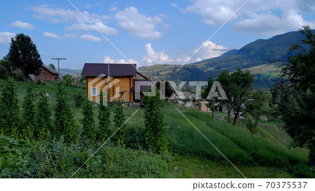 Tiny wooden house in mountain village. 70375537