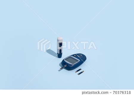 Glucose meter and pen on blue background with shadow, Metabolic syndrome concept 70376318