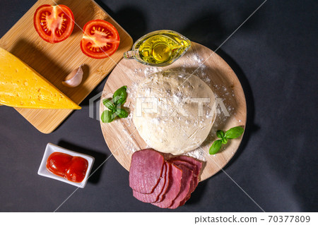 Ingredients for traditional Italian pizza on a dark background. Top view. Pizza recipe and menu. Space for text. Flat lay Ingredients for traditional Italian pizza on a dark background. Top view. Pizza recipe and menu. Space for text. Flat lay 70377809