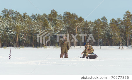 winter landscape fishermen catch fish on a frozen river winter landscape fishermen catch fish on a frozen river 70377856