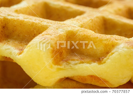 waffles Belgian, fluffy or egg waffles. Close-up traditional European dessert. food background macro textured surface. waffles Belgian, fluffy or egg waffles. Close-up traditional European dessert. food background macro textured surface. 70377857