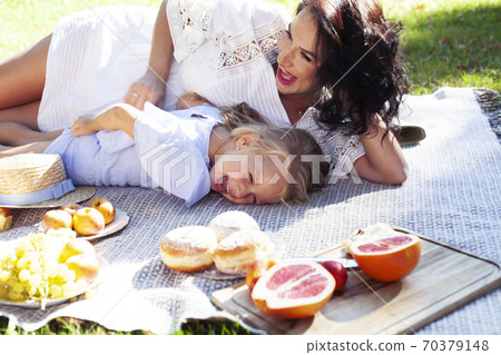 young pretty pregnant brunette woman having fun with her daughter on picnic on green grass in park, lifestyle people concept young pretty pregnant brunette woman having fun with her daughter on picnic on green grass in park, lifestyle people concept 70379148