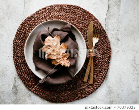 Top view of decorated table setting dish with fallen leaf. Thanksgiving or Autumn festive dinner concept. Top view of decorated table setting dish with fallen leaf. Thanksgiving or Autumn festive dinner concept. 70379322