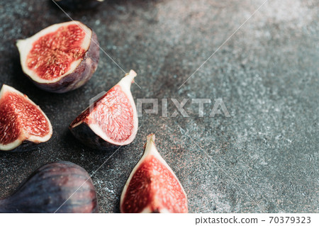 Macro photography of fresh ripe cutted figs on the textured background. Macro photography of fresh ripe cutted figs on the textured background. 70379323