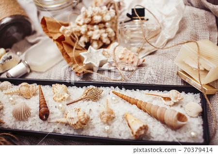 a lot of sea theme in mess like shells, candles, perfume, girl stuff on linen, pretty textured post card view vintage 70379414